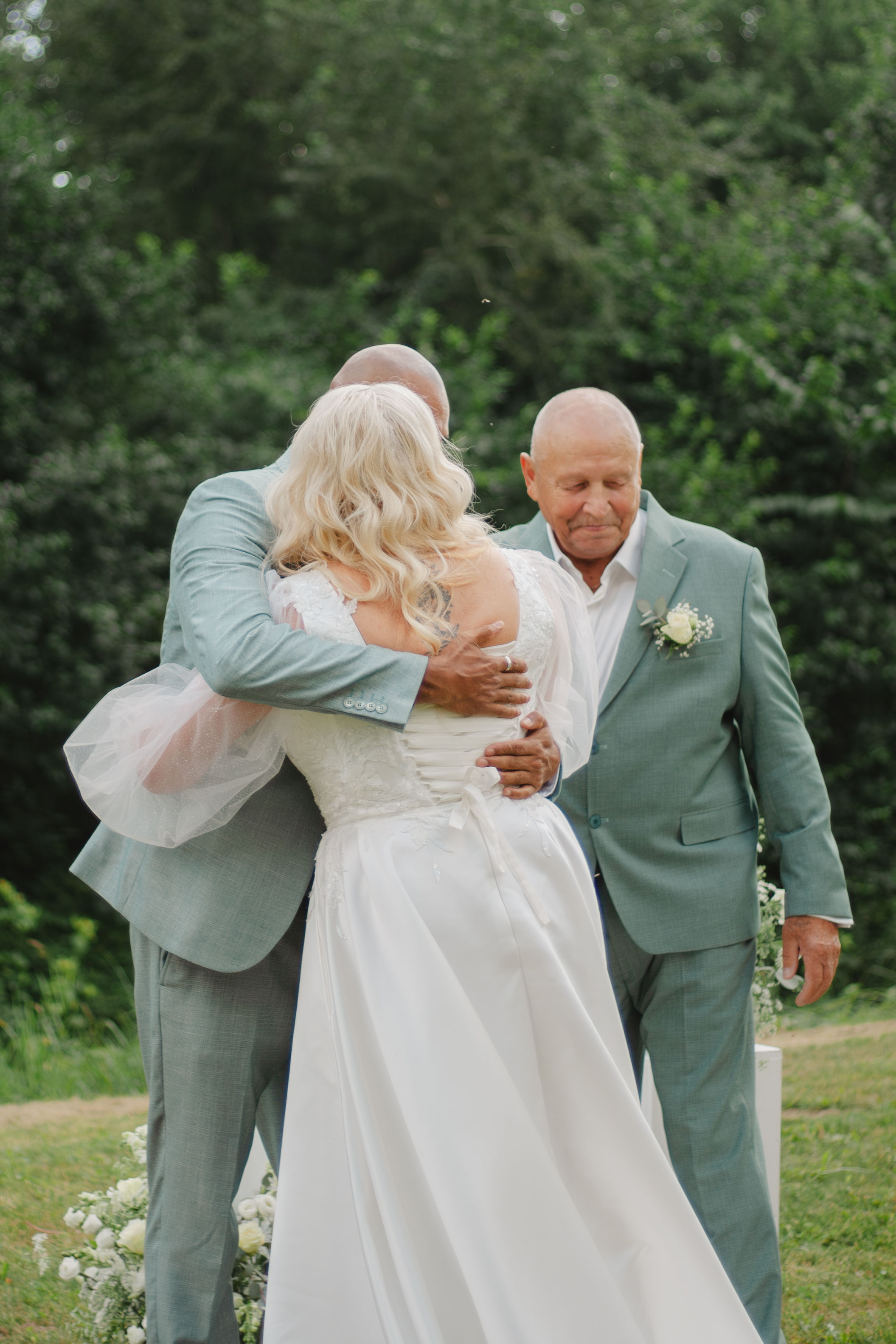 Bride and groom sharing a quiet moment with an ivory rose bouquet